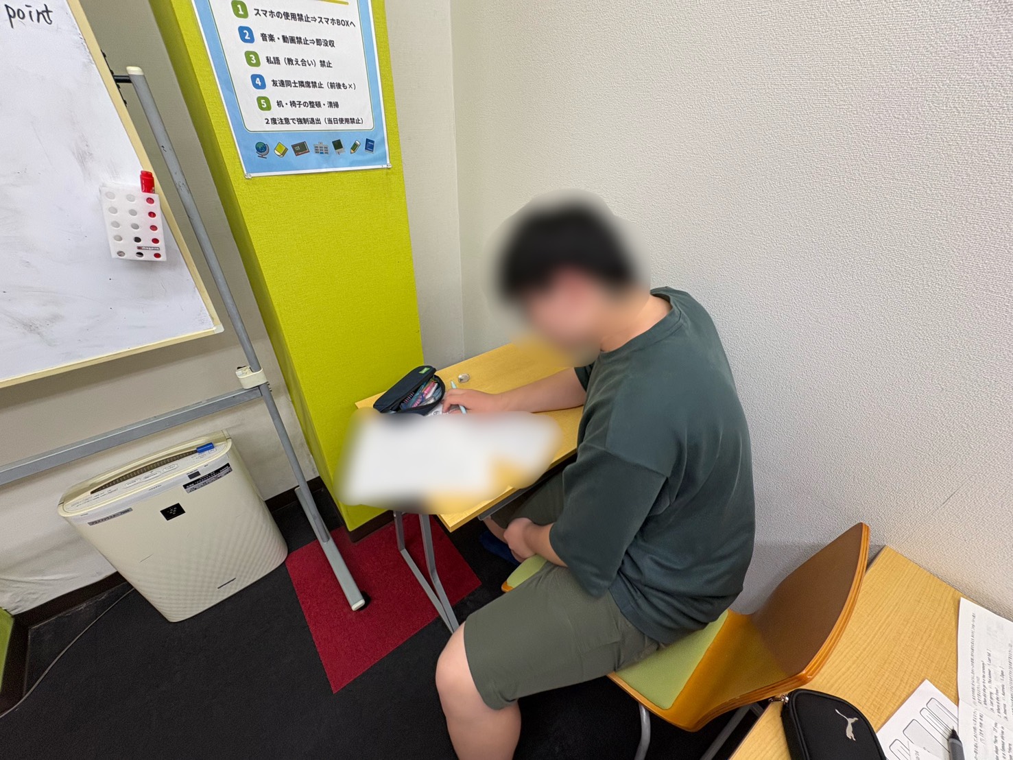 振り返りシートに3色のペンで記入している様子